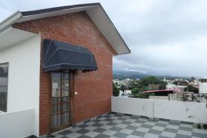 a brick building with a black awning on a balcony at Aashray in Dehradun