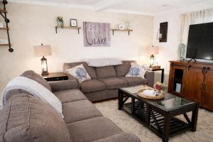 a living room with a couch and a tv at Cape Lake Private Beach Fire Table in Plymouth