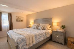 a bedroom with a large bed with two night stands and two lamps at Cape Lake Private Beach Fire Table in Plymouth