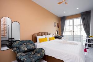 a bedroom with a large bed and a chair at Only U Home-Stay Villa Huahin in Hua Hin