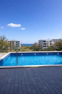 a large blue swimming pool with buildings in the background at Apartament Meraki SeaView in Mamaia Sat/Năvodari
