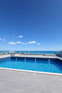 a swimming pool with the ocean in the background at Apartament Meraki SeaView in Mamaia Sat/Năvodari