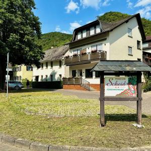 a house with a sign in front of it at Pension / Ferienwohnungen Scheid in Kestert