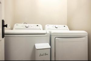 a bathroom with two white machines and a trash can at 5BR Historic Downtown Edenton in Edenton