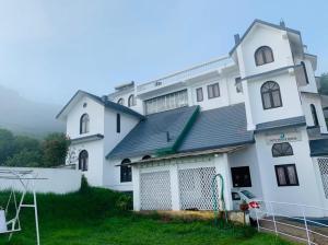 a large white building with a gate in front of it at White Legacy Ooty - Families Only in Ooty