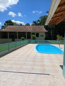 a patio with a pool in front of a house at Casa de Campo com piscina in Mairinque