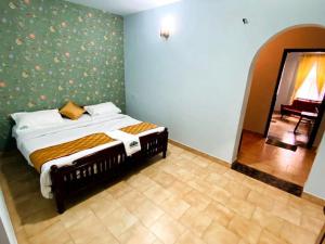a bedroom with a bed in a room with a mirror at White Legacy Ooty - Families Only in Ooty