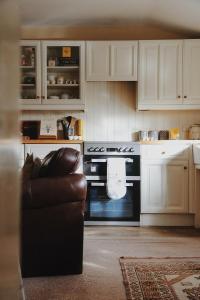 a kitchen with white cabinets and a black oven at Clock View - Haworth in Haworth