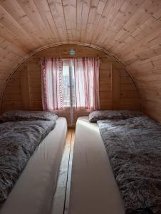 two beds in a room with a window at Schlaffass auf der Fischer-Ranch in Westerheim