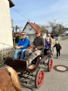 a group of people riding in a horse drawn carriage at Schlaffass auf der Fischer-Ranch in Westerheim +4 photos