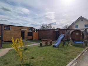 a backyard with a slide and a playground at Schlaffass auf der Fischer-Ranch in Westerheim