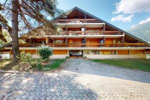 a large building with a tree in front of it at Ovronnaz , 2 pièces appartement Marana in Ovronnaz