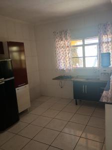 a kitchen with a counter and a window in it at Casa Amarela in Pouso Alegre