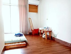 a room with a bed and a table and a window at 拉瓦宅 輕旅店 - Lawa House #僅接待18-35歲青年旅人#Only for aged 18-35 in Chiayi City