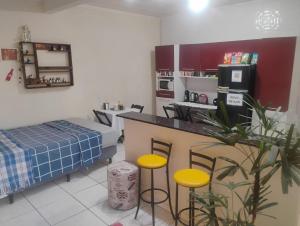 a kitchen with a counter and stools in a room at Casa Amarela in Pouso Alegre