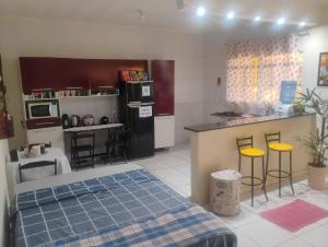 a kitchen with a bed and a kitchen with a counter at Casa Amarela in Pouso Alegre