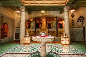a lobby with a fountain in the middle of a building at Riad Rafeef in Essaouira +98 photos