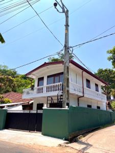a white house with a pole in front of it at Ranga's House in Weligama