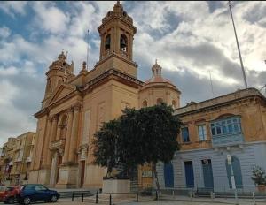 a large building with a clock tower on top of it at 17 Domus Mariae Town House in Senglea +51 photos