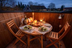a wooden table with plates of food and glasses of wine at Tiny Haus Seeadler in Schwasdorf