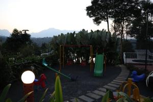 a playground with a swing set in a garden at Misty Bean Resort in Meppādi
