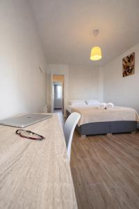 a bedroom with a bed and a table with a laptop at 5 lits, 3Ch, 100m2, Free Parking, Spacieux in Pau