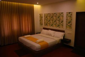 a bedroom with a bed with an orange blanket at Misty Bean Resort in Meppādi