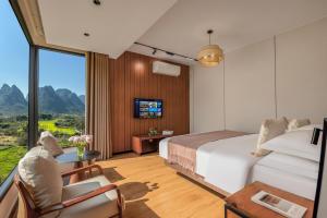 a hotel room with a bed and a large window at Meadowscape Resort at Yulong River - Karst Views & Infinity Pool & Tickets Reservation Service & Free Laundry in Yangshuo