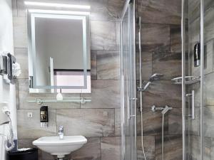 a bathroom with a sink and a shower with a mirror at Pension La Casa in Radolfzell am Bodensee