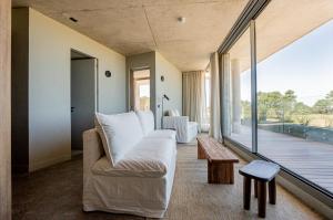 a living room with a couch and a large window at CasaChica Hotel in José Ignacio