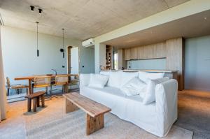 a living room with a white couch and a table at CasaChica Hotel in José Ignacio