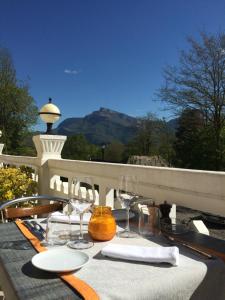 uma mesa com cadeiras e copos de vinho numa varanda em Ô Pervenches em Chambéry