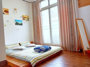 a bed in a room with a large window at 拉瓦宅 輕旅店 - Lawa House #僅接待18-35歲青年旅人#Only for aged 18-35 in Chiayi City +23 photos