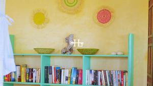 a green book shelf with books and baskets on it at Kavunjeni Villa in Uyombo