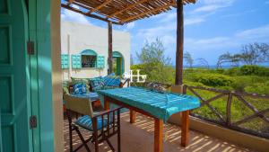 a patio with a table and chairs on a balcony at Kavunjeni Villa in Uyombo