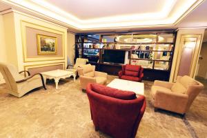 Atlıhanpark Hotel في بطمان: غرفة معيشة بها كنب وكراسي وتلفزيون