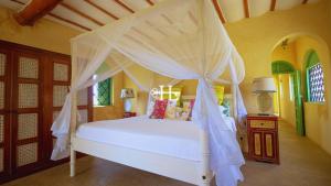 a bedroom with a white bed with a canopy at Kavunjeni Villa in Uyombo +43 photos
