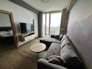 a living room with a couch and a tv at Apartmán Tatrya in Vysoké Tatry +8 photos