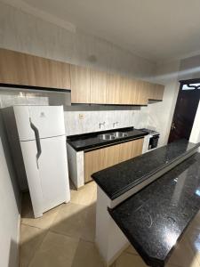 a kitchen with a white refrigerator and a sink at Casa Bragança in Bragança