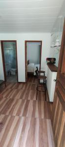 a room with a table and a chair and a bedroom at Chalé da Helô in Nova Friburgo