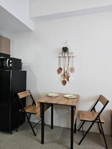 a dining room table with two chairs and a black refrigerator at BE Residences Lahug in Cebu City +8 photos
