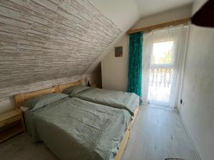 a bedroom with a bed and a large window at Lukács nyaralóház in Balatonfenyves