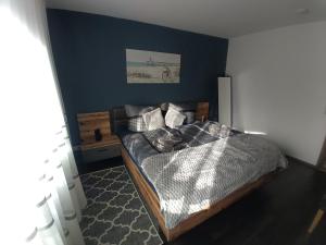 a bedroom with a bed and a blue wall at EDGE of FOREST in Titisee-Neustadt
