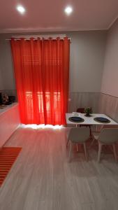 a room with a red curtain and a table and chairs at Maison Aielli 112 in San Giuseppe Vesuviano