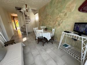 a room with a table and chairs and a bedroom at Lukács nyaralóház in Balatonfenyves