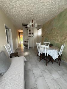 a dining room with a table and chairs and a bed at Lukács nyaralóház in Balatonfenyves