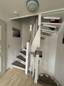 a staircase in a living room with white walls at Dat Südstrandhuus- Ferienwohnung Silke in Wyk auf Föhr