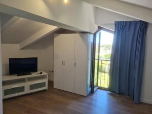 a living room with a tv and a large window at Stella Marina Paestum in Paestum