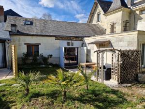 a house with a fence in front of it at Le Pressoir in Turquant