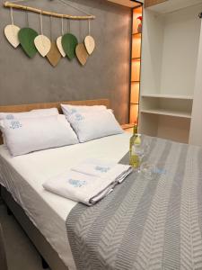 a bed with towels and a bottle of wine on it at Beira mar Flat Deluxe Nomar Carneiros Ecoliving Réveillon in Tamandaré +70 photos